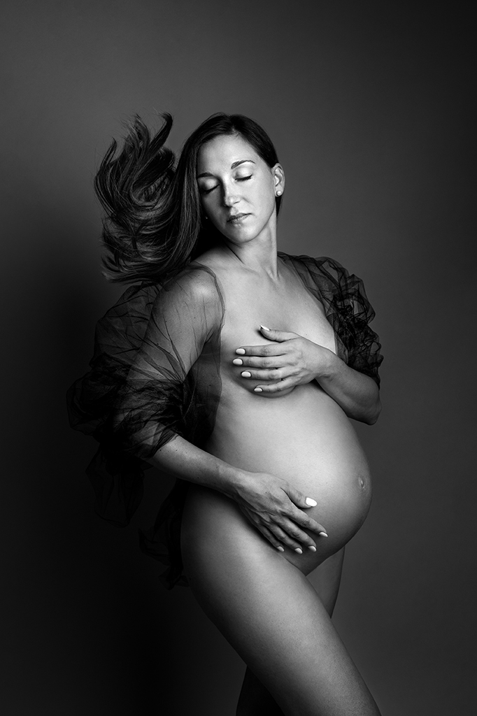 Foto Fine Art in bianco e nero di maternità di una donna incinta, con un velo trasparente sulle spalle. Fotografia Fine Art in bianco e nero di maternità di una donna con un velo sulle spalle Italia