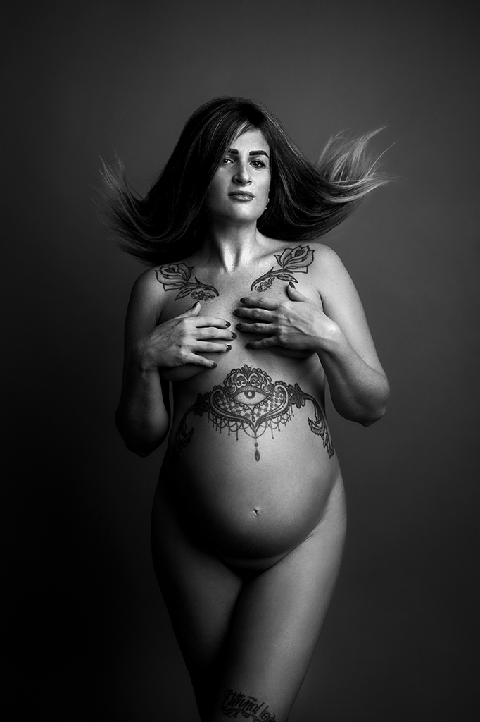 Foto artistica in bianco e nero in studio di maternità in studio con donna tatuata nuda. Fotografia artistica in bianco e nero di maternità in studio con donna nuda tatuata Trieste