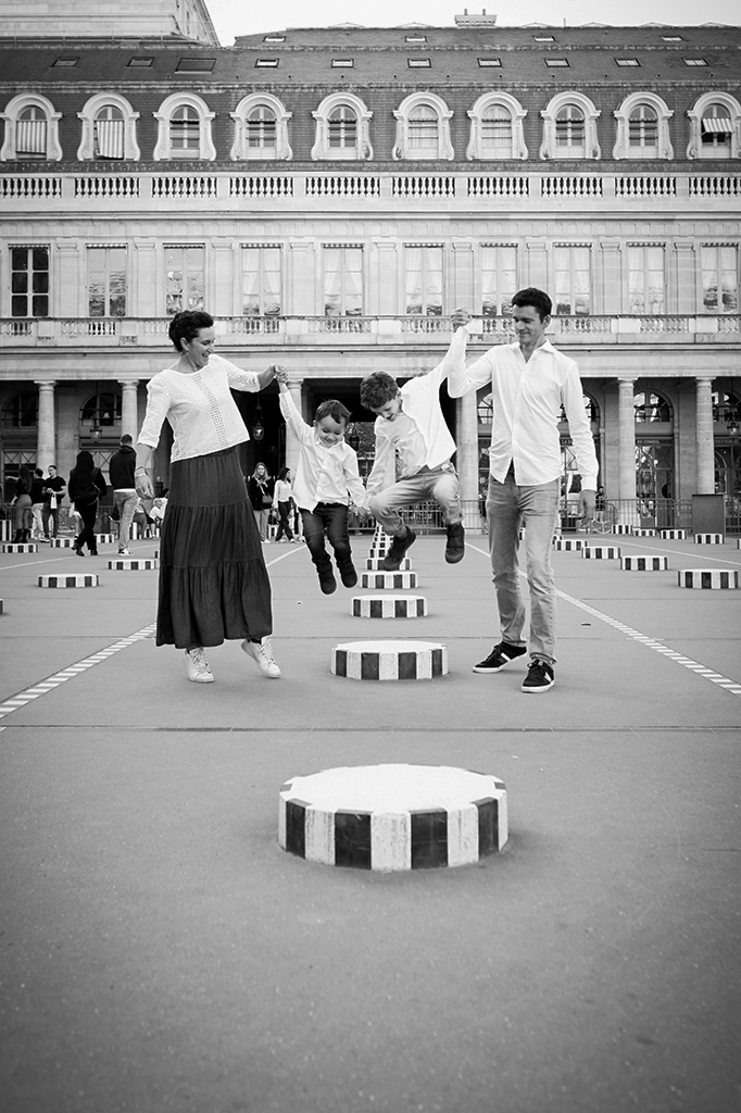 Foto in bianco e nero fuori studio a Parigi, di una famiglia che gioca. Fotografia in bianco e nero di una famiglia a Parigi Trieste