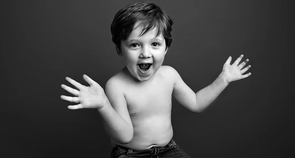 Foto in bianco e nero ritrattistica di un bambino senza maglia con una faccia sorpresa. Fotografia in bianco e nero ritrattistica di un bambino Trieste