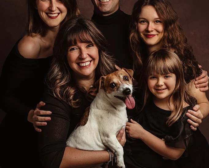 Foto ritratto di famiglia con cane a colori su sfondo scuro. Fotografia ritrattistica di famiglia a colori Italia