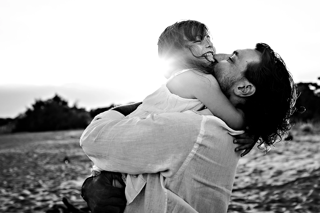 Foto in bianco e nero fuori studio di un padre che abbraccia la figlia. Fotografia fuori studio Trieste