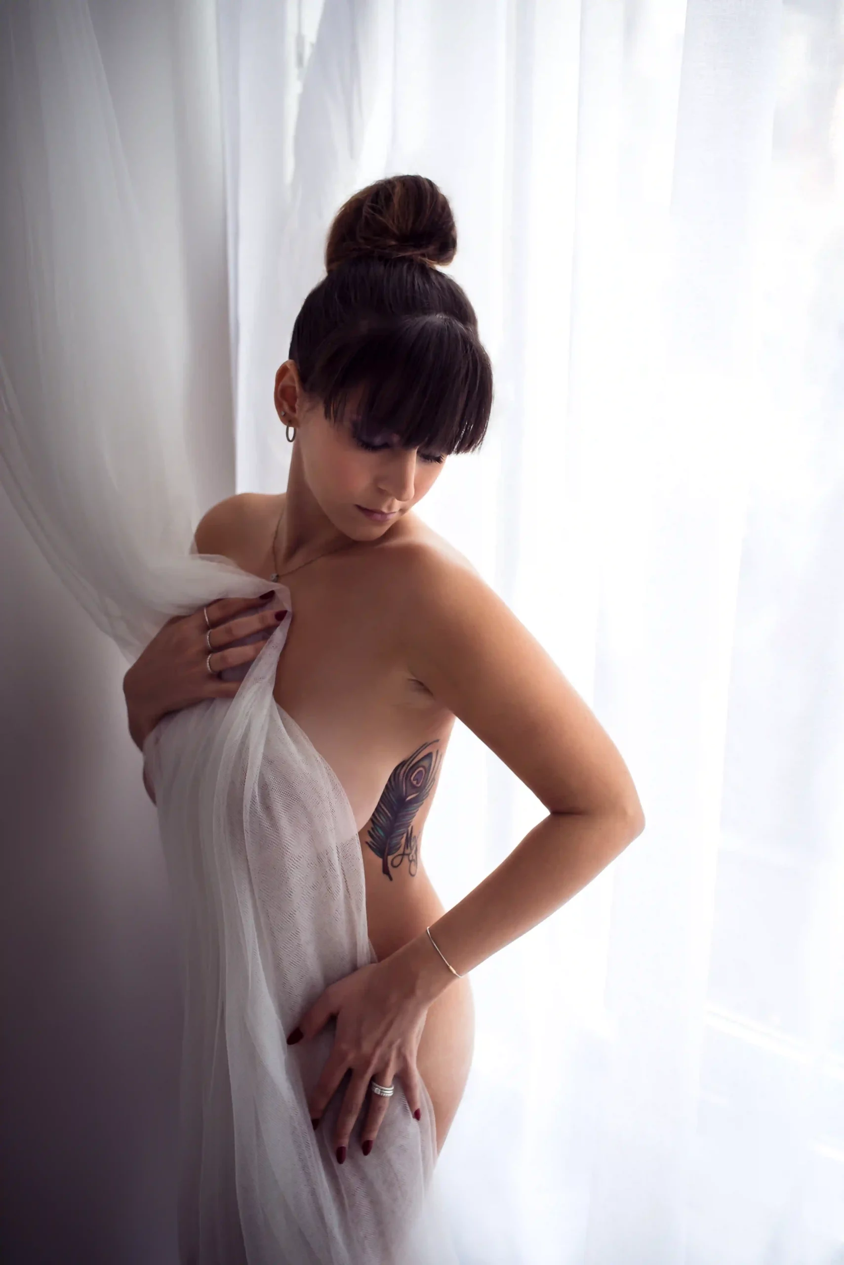 Foto donna nuda avvolta dalle tende in maniera sensuale. Fotografia boudoir Italia